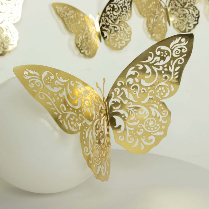 Gold decorative butterfly with intricate cutout patterns on a white background.