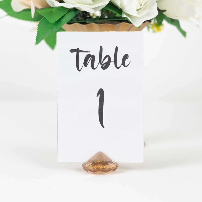 Table number 1 sign with decorative holder in a floral arrangement.