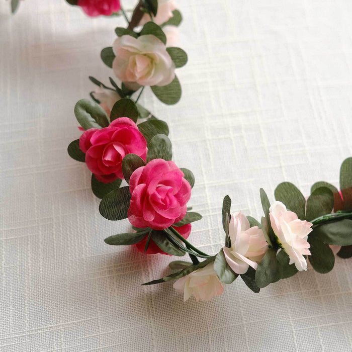 Colorful floral garland with pink and white flowers on a light background.