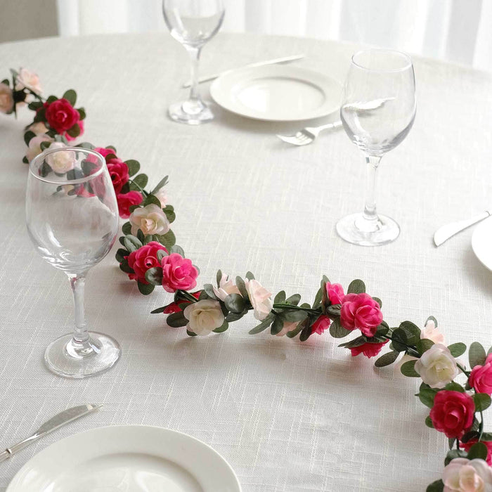 Floral table garland with pink and white roses on a dining table setting.