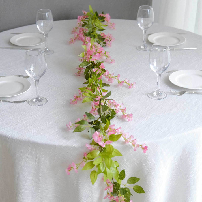 Table setting with pink floral centerpiece and wine glasses.