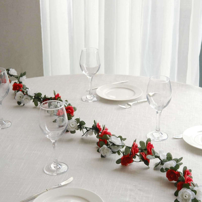 Floral table centerpiece with red and white flowers and wine glasses