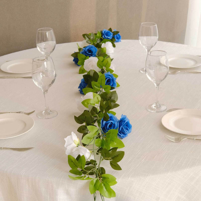 Elegant table setting with blue and white rose garland and glassware.