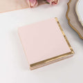Pink notepad with gold foil edges on a white background