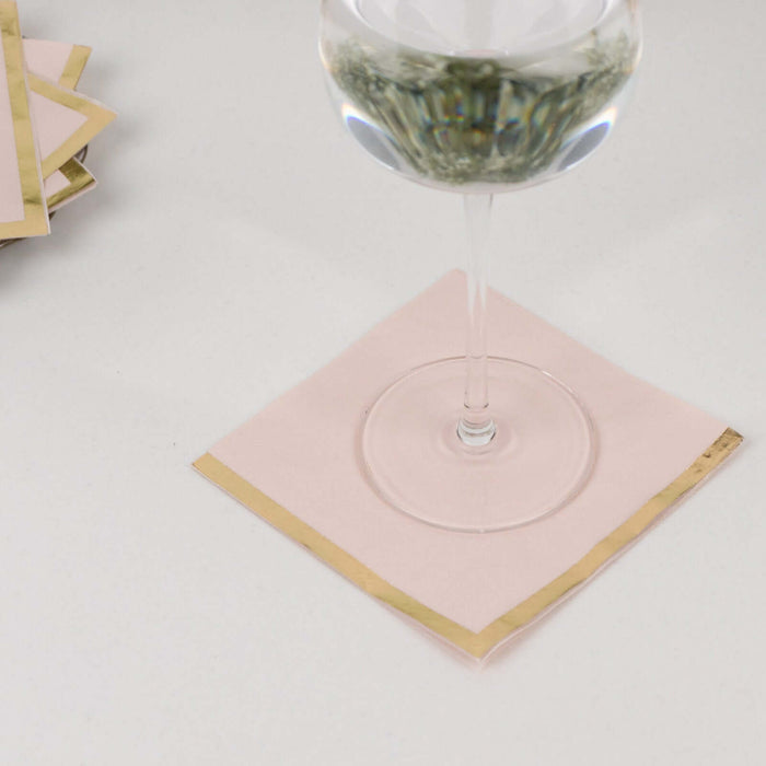 Pink napkin with gold trim under a glass of water