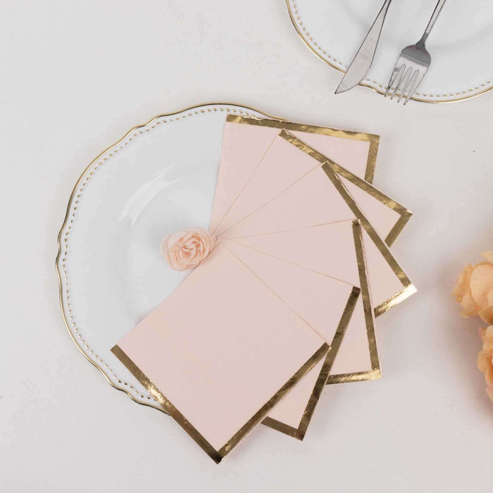 Pink stationery with gold foil edges displayed on a white plate.