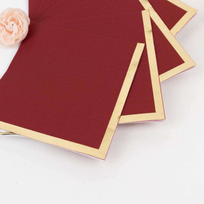 Burgundy stationery with gold foil edging, elegantly arranged.