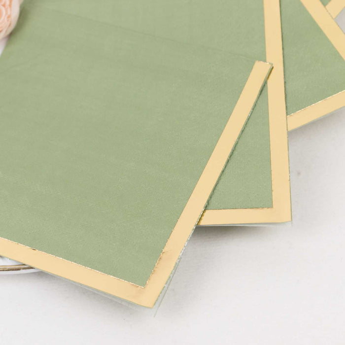 Green notecards with gold edges stacked on a white background.