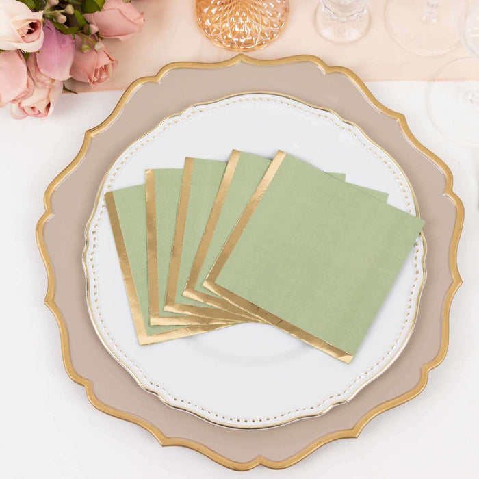 Green napkins with gold edges arranged on an elegant plate.