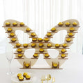 Butterfly-shaped cupcake display with golden cupcakes on tiers.