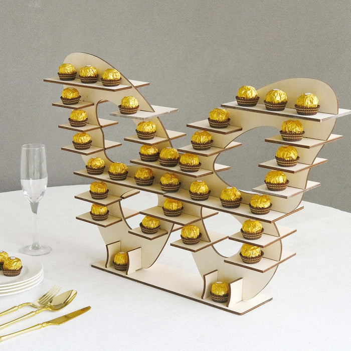 Cupcake stand display with gold-wrapped treats and elegant glassware.