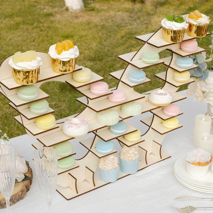 Colorful dessert display stand with cupcakes and macarons at an outdoor event.