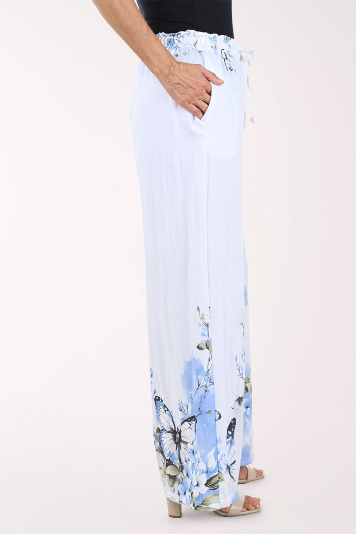 White pants with blue butterfly pattern worn by a person on a white background