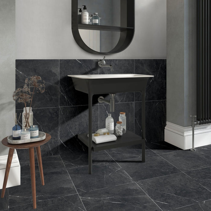 Bathroom with black marble effect tiles on the floor and the wall behind basin.