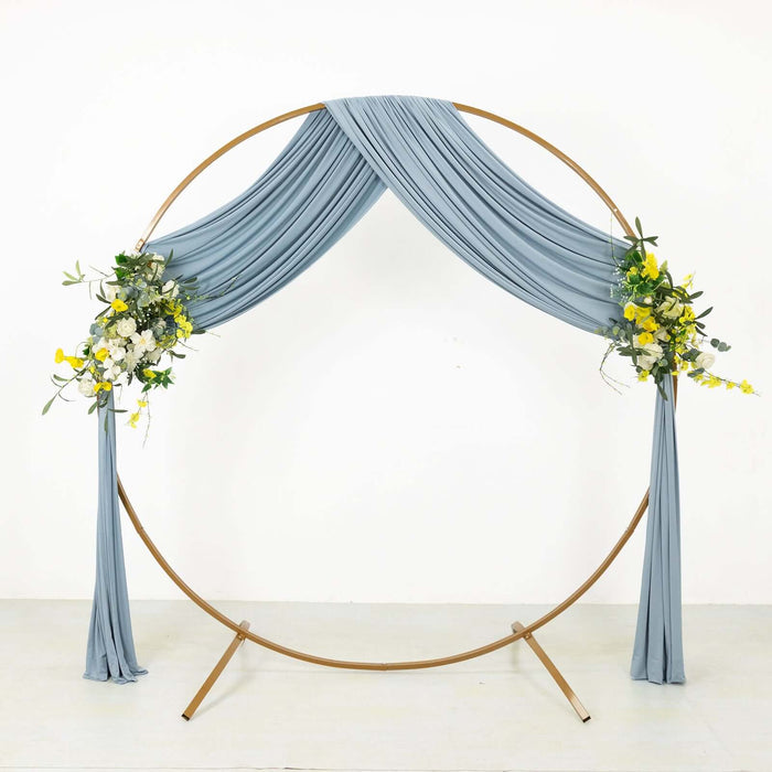 Blue draped wedding arch with floral accents on a plain background