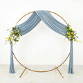 Blue draped wedding arch with floral accents on a plain background