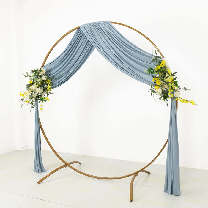 Round wedding arch with blue drapery and floral arrangement