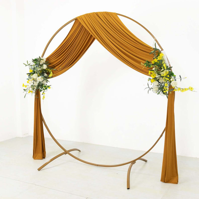 Bronze wedding arch with draped fabric and floral accents