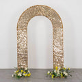 Gold sequin wedding backdrop arch with floral arrangements on the base.