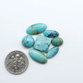 Hubei Cloud Mountain Turquoise cabochons, blue and green color with black matrix, polished stones on a white background, with a US dime for scale