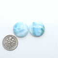Larimar stone cabochons, cut and polished, blue and white gemstones on a white background, with a US dime for scale