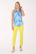 Woman wearing a colorful sleeveless top and yellow pants on a white background