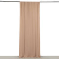 Beige fabric drapery hanging from a black rod against a plain backdrop