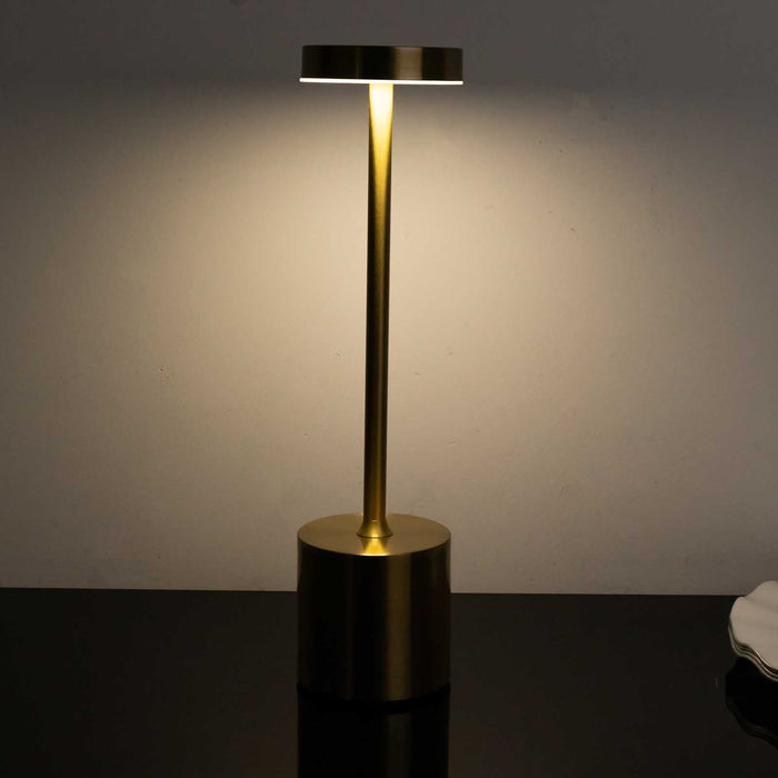Modern brass table lamp with minimalist design and warm light.