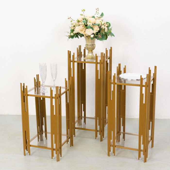 Gold metal plant stands with glass tops and a floral arrangement.