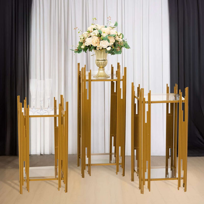 Elegant gold display stands with a floral arrangement on top.
