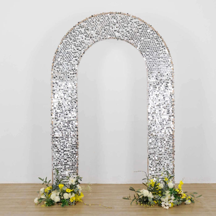 Decorative silver arch with floral arrangements at the base.