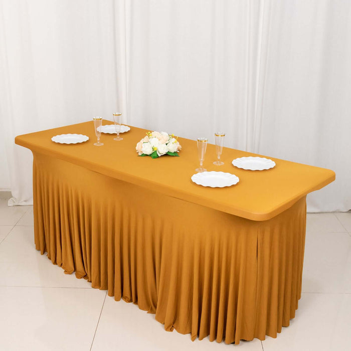 Elegant mustard table with pleated skirt and white plates, styled for an event.