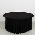 Black round table with pleated skirt, studio shot.