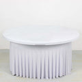 Round table with white draped skirt on plain background