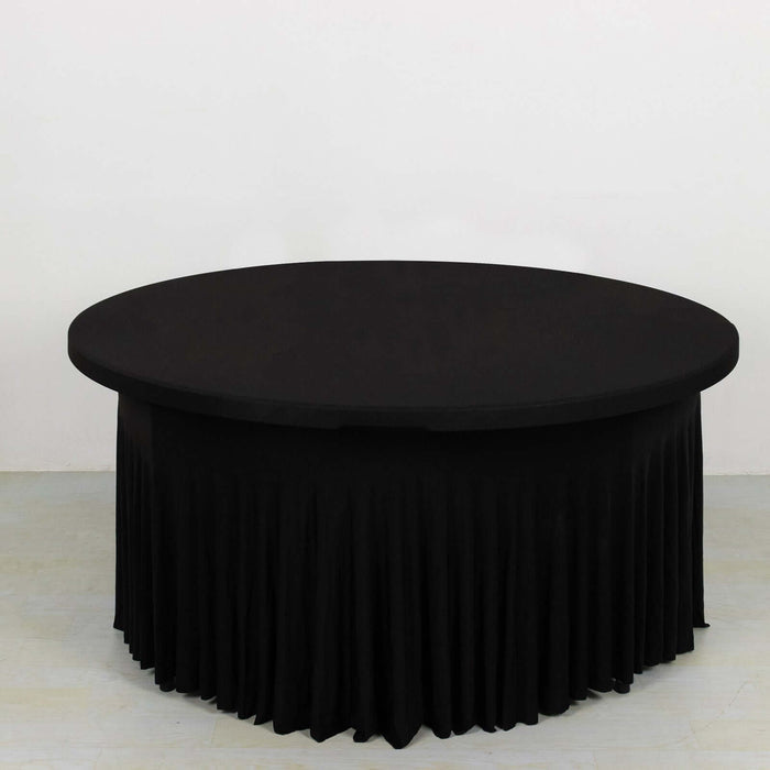 Black round table with pleated skirt on a plain background