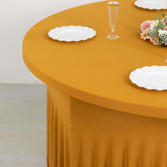 Round mustard table with white plates and floral centerpiece.