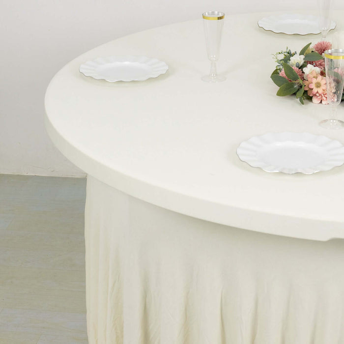 Round white table with plates and decorative flowers on a plain background.
