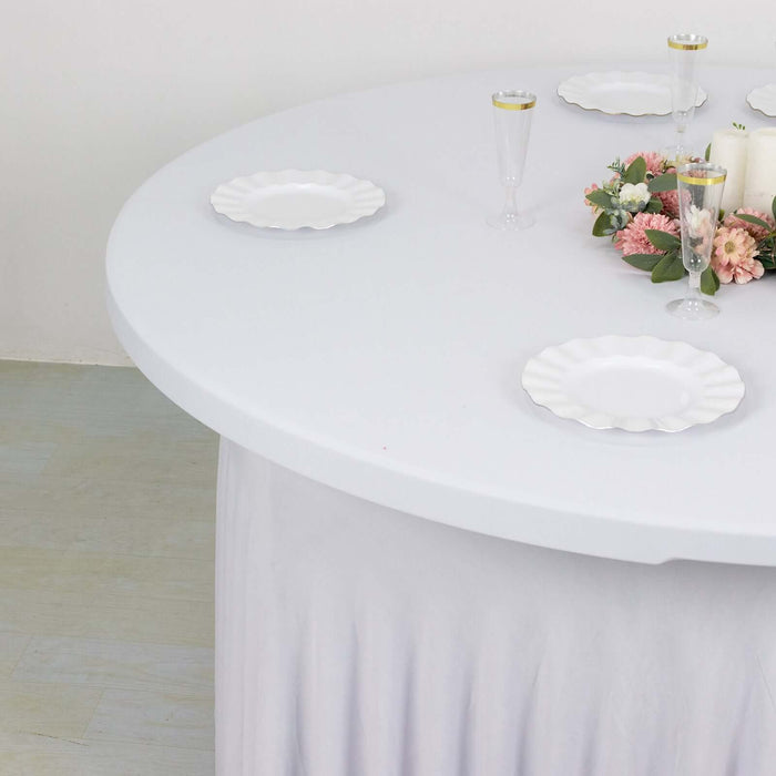 Round table set with elegant plates and floral centerpiece.