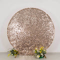 Rose gold sequin backdrop with floral arrangements at the base.