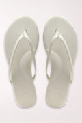 Pair of white flip-flops on a light gray background