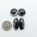 White Buffalo stone cabochons, white stone with black matrix, polished stones on a white background, with a US dime for scale